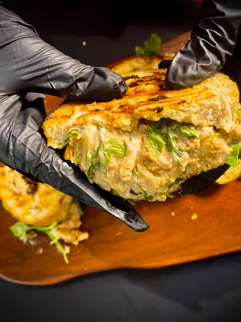 Close-up of cheesy pulled smoked chicken sandwich